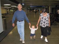 10-Grandpa_and_Baba_holding_Kenny's_hands_walking_through_the_airport
