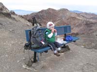 14-Kenny_woke_up_for_lunch_on_the_peak-sitting_like_a_big_boy-Red_Mountain_in_background
