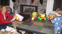 007-Mommy_opens_a_Kenny_gift_while_Kenny_plays_with_his_trucks