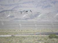 04-unmanned_Predator_drone_landing_after_a_test_bombing_measure_from_Creech_AFB-as_seen_along_Hwy_95