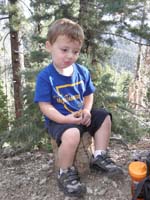 32-Kenny_eats_a_snack_while_sitting_on_a_stump