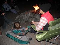 79-Kenny_and_Mommy_sitting_by_the_campfire_eating_cupcakes