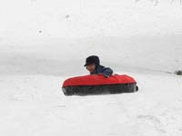 65-sequence_photos_of_Kenny_tubing_down_the_hill-he's_really_happy