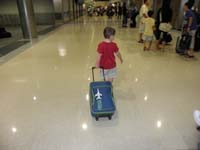 09-Kenny_finally_arrives_in_Atlanta-pulling_his_luggage_through_the_airport