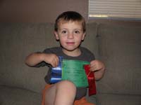 15-Kenny_with_his_graduation_certificate_and_swim_meet_ribbons