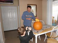 02-Kenny_takes_a_picture_of_Daddy_cutting_off_the_top_of_the_pumpkin