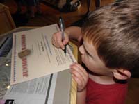 76-Kenny_signs_his_certificate