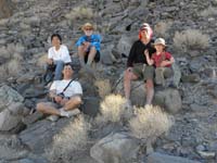 051-Kay_Daddy_Henry_Peppe_and_Kenny_take_a_rest_along_a_slope_where_rocks_start_their_journey