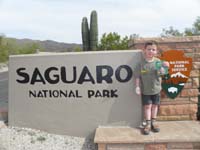 064-Kenny_shows_of_his_Junior_Ranger_certificate_and_badge_at_entrance_to_Saguaro_NP_East