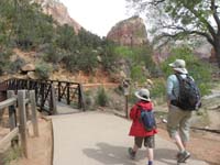 01-Kenny_and_Mommy_start_the_hike-Angels_Landing_in_distance-Kenny's_pack_weighs_5_pounds