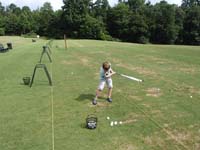 23-trying_his_luck_hitting_golf_balls_at_a_driving_range