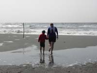 06-Mommy_and_Kenny_take_off_their_shoes_and_walk_towards_the_water-note_the_puddle