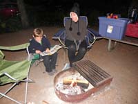 06-Kenny_reads_a_book_at_the_campfire