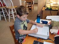 19-Kenny_solving_math_problems_to_practice_before_starting_school