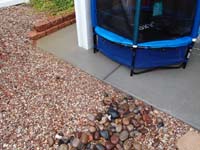 29-water_pooling_and_entering_pipe_in_rocks_and_under_patio