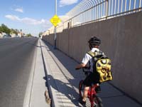 37-riding_on_sidewalk_along_main_road-careful_at_hidden_driveway_ahead
