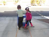 45-Kenny_and_Sarina_now_try_using_their_scooters_to_push_harder