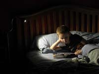 56-Kenny_reading_a_book_in_bed_using_his_new_night_light