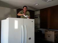 22-Daddy_cleaning_the_top_of_the_refridgerator-we_are_moving_in