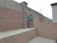 26-Kenny_showing_how_to_climb_over_our_wall_using_a_wooden_ladder_Daddy_made_using_construction_debris