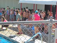 04-lots_of_kids_waiting_to_start_swimming-Kenny_is_in_the_middle_with_blue_goggles_on_his_forehead