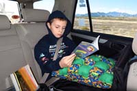 01-Kenny_reading_during_the_ride_to_Death_Valley-Daddy_using_his_new_camera