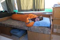 54-Kenny_gets_to_sleep_in_different_place_than_usual_easier_since_not_using_table-use_other_bed_for_storage