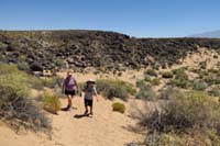 23-hiking_along_sandy_trail_through_hot_cloudless_desert-we_are_tourists