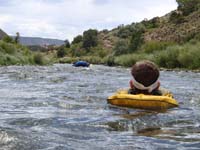 36-Kenny_floating_down_Rio_Grande-approaching_small_rapid-keep_legs_up