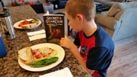56-Kenny_reading_'Secret_of_the_Staircase'_while_waiting_for_dinner_to_cool_down