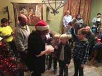 046-helping_to_hand_out_gifts_with_Noah-6,Lucas-8-they_latched_onto_Kenny_even_following_him_to_bathroom