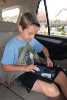 03-what_Kenny_enjoys_doing_while_riding_car_to_his_birthday_party-play_Minion_Rush_on_his_tablet