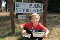 091-Kenny_shows_off_his_badge,certificate,volcanic_rocks_at_Paulina_Visitor_Center