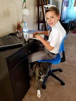 45-Kenny_at_his_desk_doing_his_homework_after_school-Rainer_helps