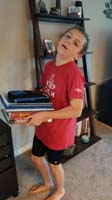 26-Kenny_seems_overwelmed_by_the_weight_of_all_his_books_and_homework_for_6th_grade