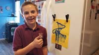 30-Kenny_is_proud_of_his_art_work_from_school-grade_S+