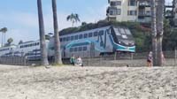 02-passenger_train_runs_along_beach_edge