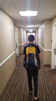 002-Kenny_ready_for_swim_practice-walking_through_hotel_corridor-saw_an_cleaning_employee_with_no_mask