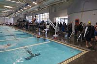 048-pool_area_quite_busy,no_coordination_limiting_number_of_people,at_least_this_lifeguard_wears_a_mask